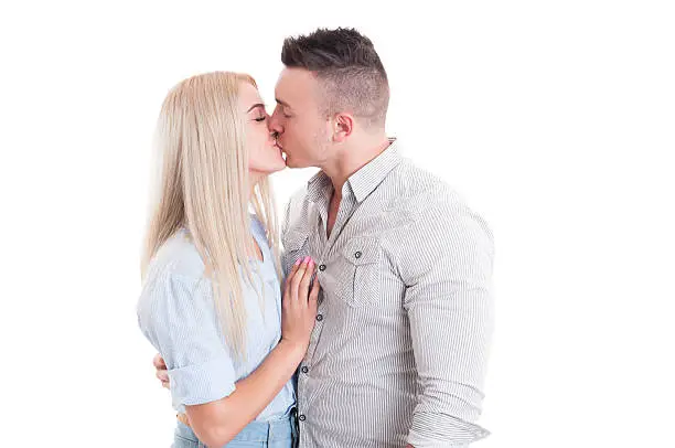 Young couple inlove kissing waist up on white studio background