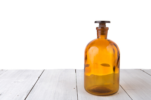 medicine bottle on wooden table isolated on white
