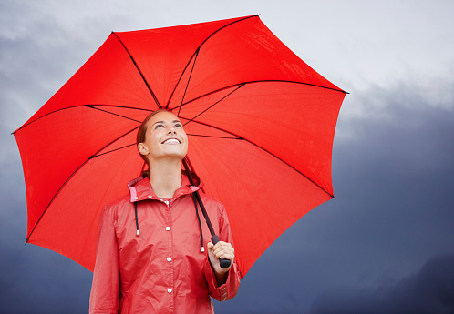 woman holding a big red umbrella On the day when the sky was overcast, it seemed like a storm was about to happen.