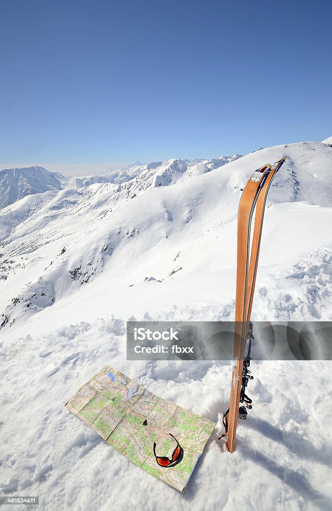 On the summit Pair of back country ski with sealskin, map and sunglasses on the top of the mountain with majestic view of the italian alpine arc. Looking At View Stock Photo