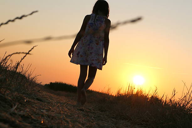 istock Girl walking at sunset 481534926