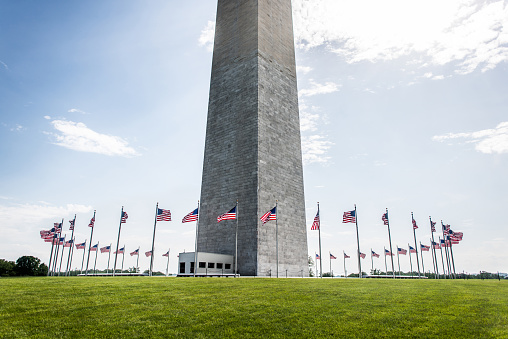 Washington Monument with the top cut of to focus on the flags in a sunny summer day