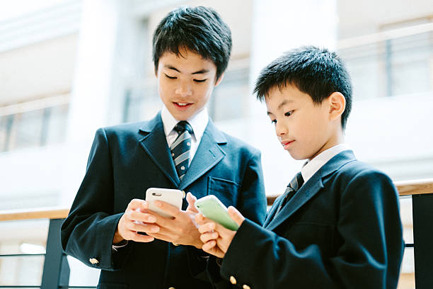 日本の学校の学生の学校でスマートフォンを使用して - japanese culture asian ethnicity friendship computer ストックフォトと画像
