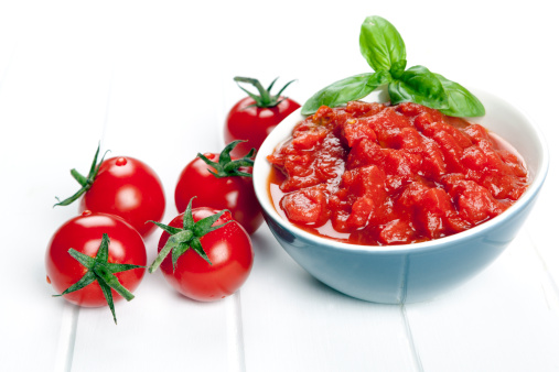 Diced and whole tomatoes. garnished with basil.Diced and whole tomatoes, with olive oil behind.  Garnished with basil.