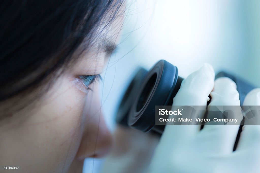 Student working with a microscope Adult Stock Photo