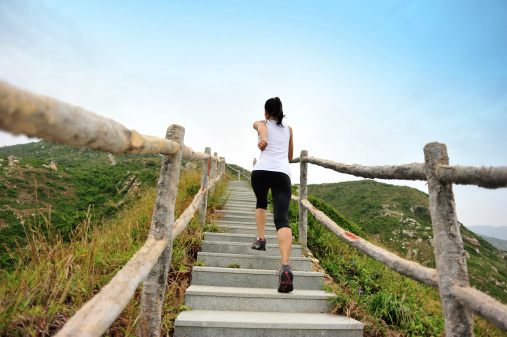 woman runner running at mountain stairs