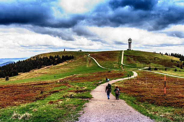 FELDBERG, GERMANY - MAY 17 2015: People hiking at Feldberg Mountain in Germany in Spring. Lovely Hills and Forests. Blue cloudy sky. Fantastic Landscape