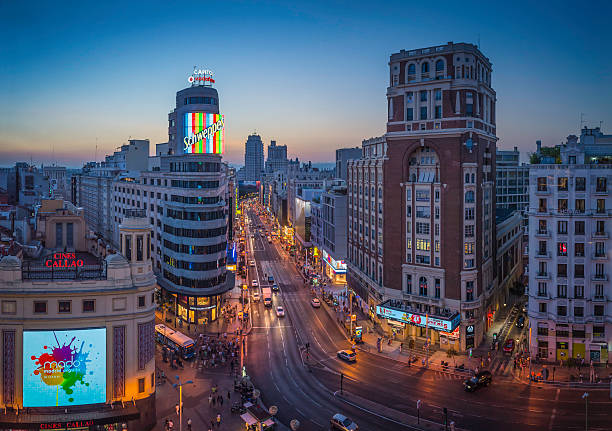 madrid gran via affollata via commerciale monumenti illuminato tramonto spagna - gran vía foto e immagini stock