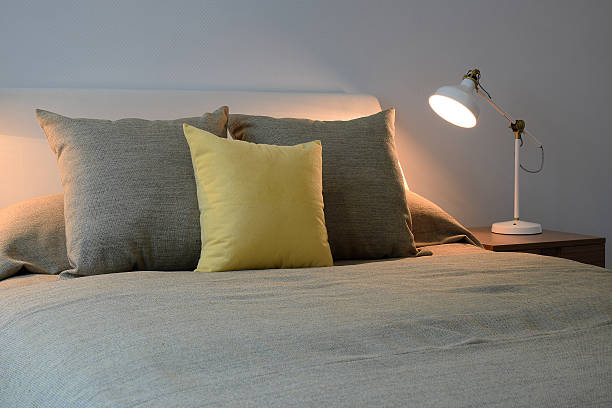 istock Cozy bedroom interior with pillows and reading lamp 481564006