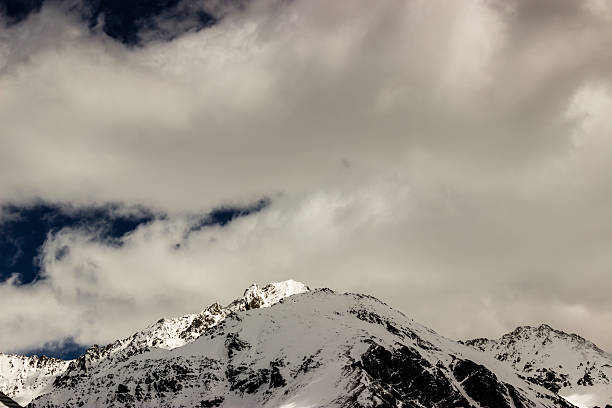 istock mountain peak under the cover of clouds and snow 481564156