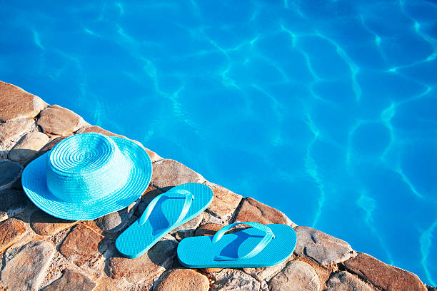 istock Blue  hat  and flip flop by a swimming pool 481564440
