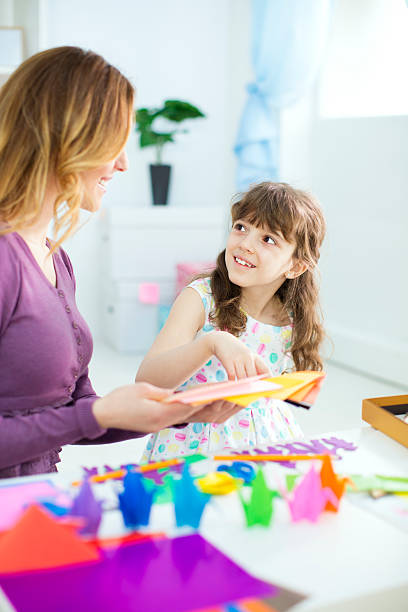 istock Mother and daughter making origami. 481566833