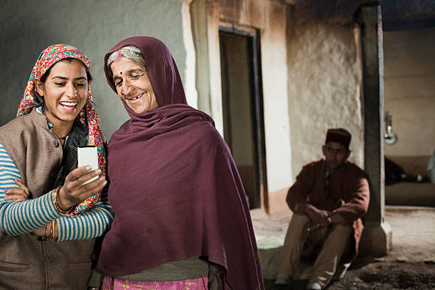 rural menina adolescente feliz mostrando o telemóvel para avó dela. - wireless technology cheerful granddaughter grandmother imagens e fotografias de stock