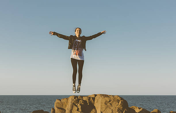 девушка, прыгать от радости - arms outstretched teenage girls jumping flying стоковые фото и изображения