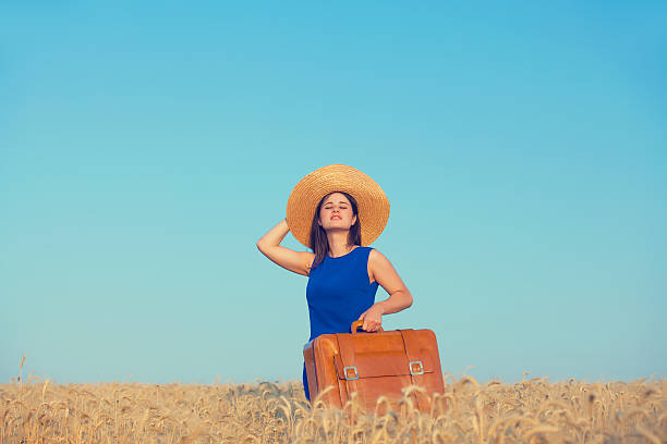 istock girl with suitcase at wheat field 481567822