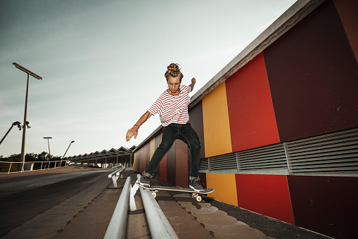 Female skateboarder grinding urban rails