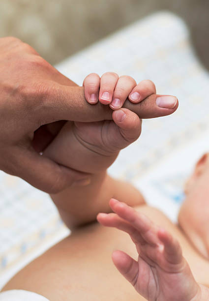 istock Child's hand holding mother's finger 481568232