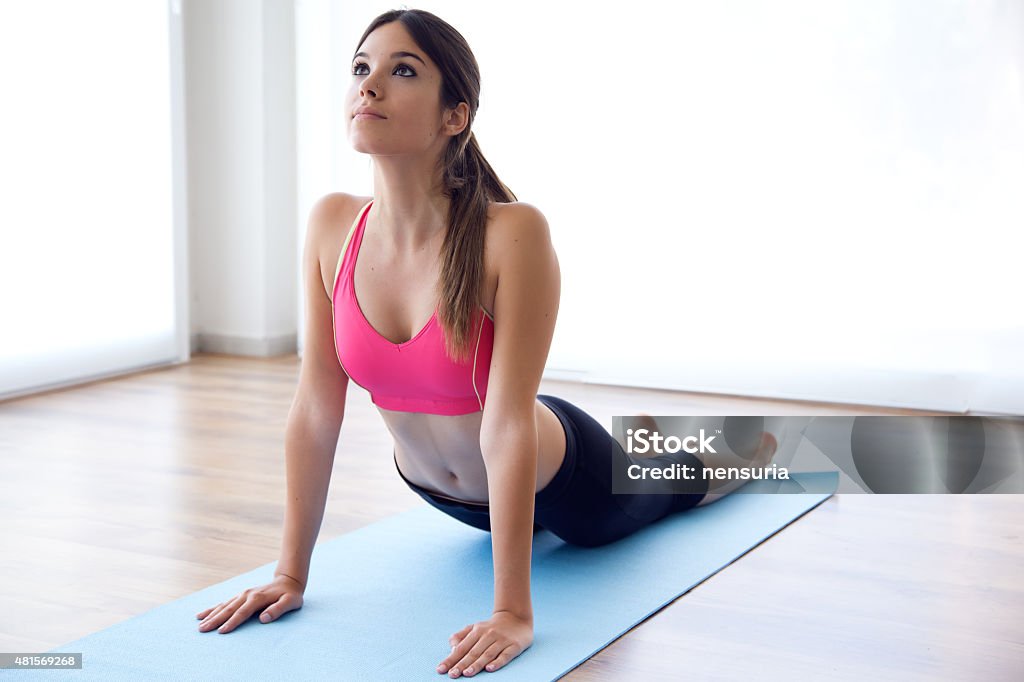 Beautiful healthy young woman doing exercise at home. Portrait of beautiful healthy young woman doing exercise at home. 2015 Stock Photo