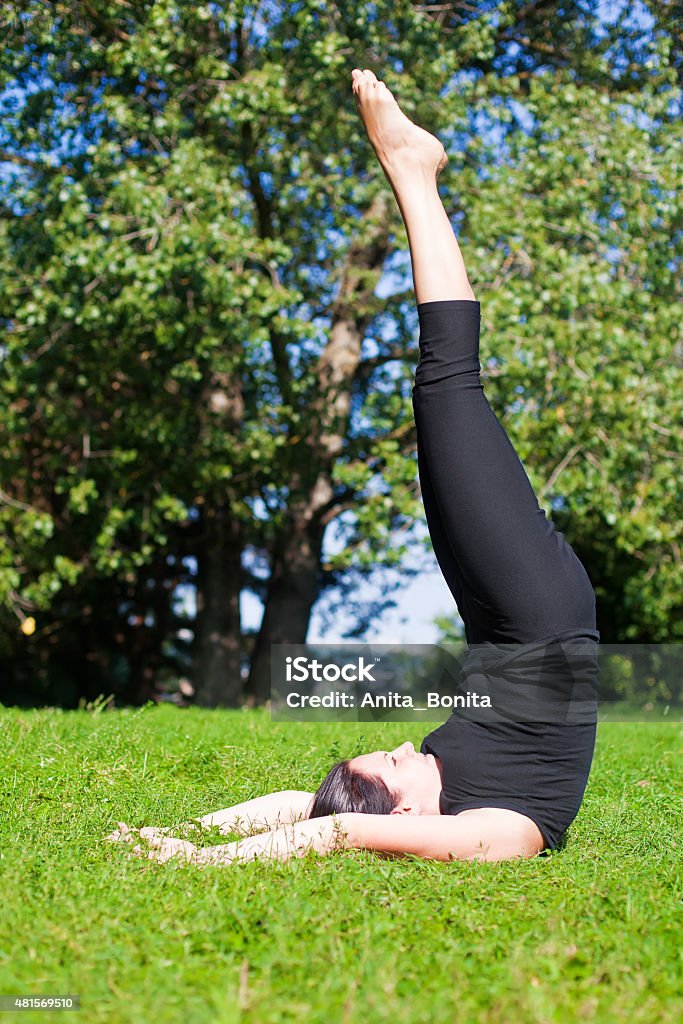 Sarvangasana - Shoulderstand woman in black making yoga shoulderstand - sarvangasana 2015 Stock Photo