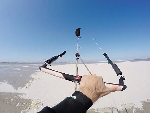 A kiteurfer holding his kite on the beach of St.Peter-Ording in Germany. GoPro Hero 4 black edition image.