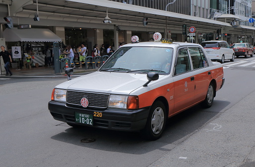 Kyoto Japan - May 6, 2015: Japanese taxi drives through Kyoto downtown in Kyoto Japan. 