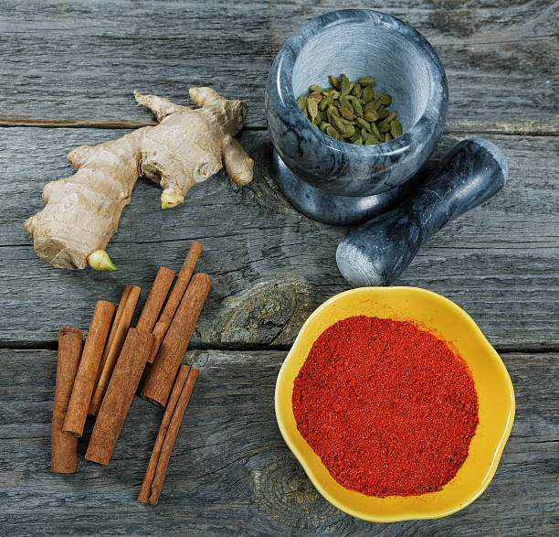 ainda-vida com gengibre e canela em uma antiga mesa de cozinha - cardamom cinnamon mortar and pestle herb imagens e fotografias de stock