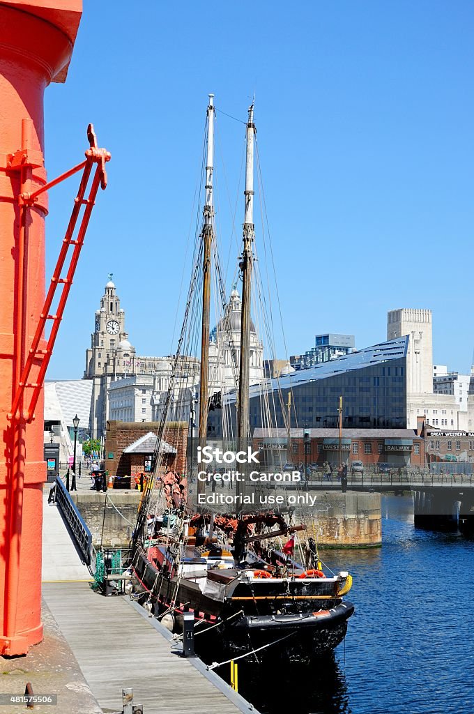 Albert Dock, Liverpool. Liverpool, United Kingdom - June 11, 2015: Yachts moored in Albert Dock with the Three Graces to the rear and tourists enjoying the sights, Liverpool, Merseyside, England, UK, Western Europe. 2015 Stock Photo