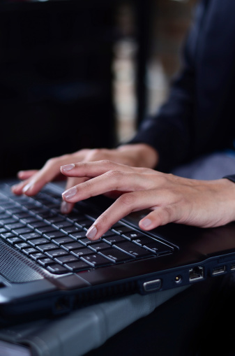 Woman hands typing on laptop