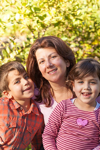 istock Mother Embracing Her Son and Daughter 481577210