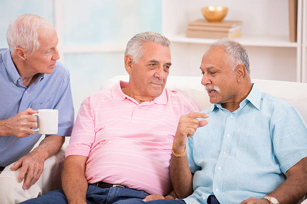 diverso grupo de senior hombres consola de un amigo.  el ambiente hogareño. - senior adult group therapy social gathering community center fotografías e imágenes de stock