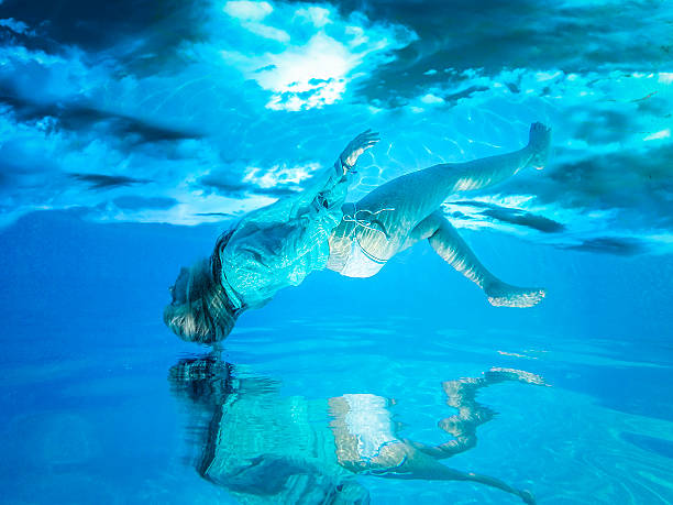 istock Woman under water with a blue sky with clouds 481577390