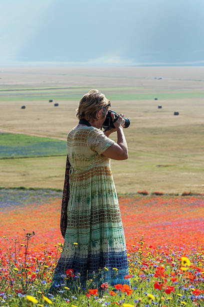 photographe en robe longue bleu-vert près de castelluccio, italie - natural landmark outdoors vertical saturated color photos et images de collection