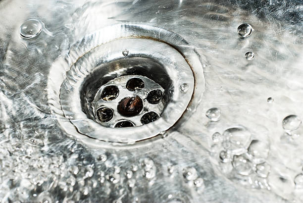 istock Stainless steel sink plug hole close up with water 481578597