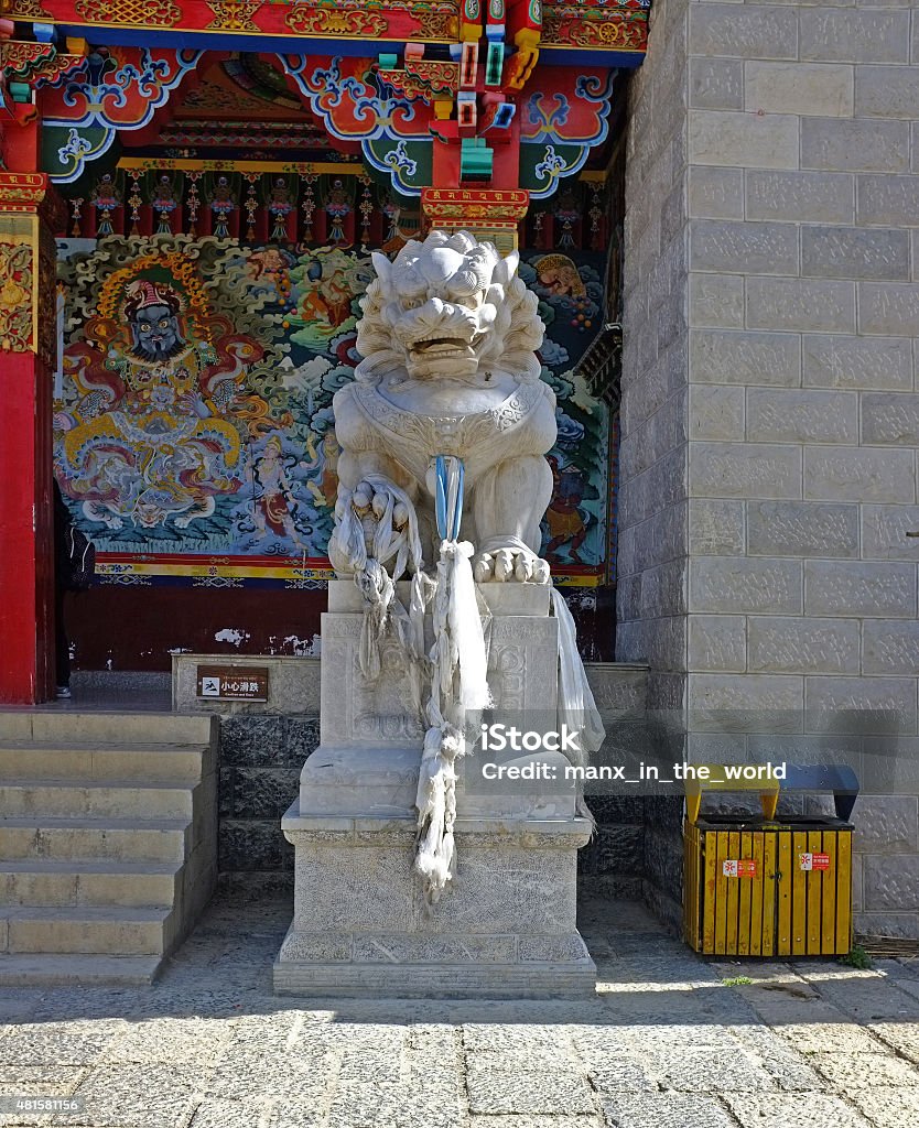 Ganden Sumtseling Monastery in Shangri-La. China, Yunnan.  Stone Lion guarding the  Ganden Sumtseling Monastery (also known as: Ganden Sumtseling Gompa, Songzanlin Si, Sungtseling and Guihuasi), largest Buddhist monastery in Yunnan province.  Sometimes referred to as the Little Potala Palace.  It is the home for 600 monks of the Yellow Hat sect of Tibetan Buddhism of the Gelukpa order of the Dalai Lama. 2015 Stock Photo