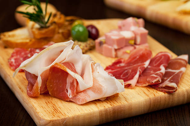 Antipasto board with prosciutto salami and other goodies Antipasto board with prosciutto salami and other goodies salumeria stock pictures, royalty-free photos & images