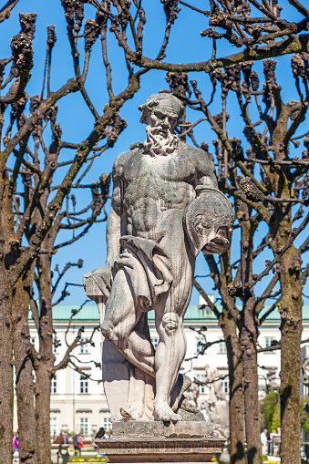 greek statues in Mirabell gardens in Salzburg under plane trees