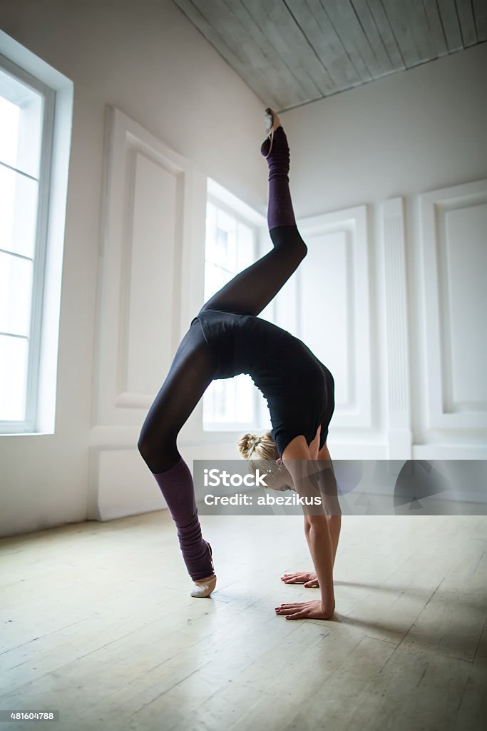 Flexible gymnast doing exercise Flexible gymnast doing exercise, bending back at the bridge. 2015 Stock Photo