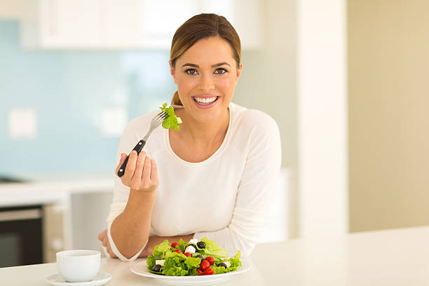 istock healthy young woman eating salad 481604802