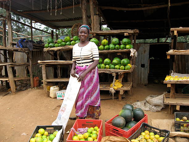 Thika, Kenya-September 12, 2006:  Just outside of Thika at a roadside stand a woman sells fruit at her fruit stand.  Fruit stands line the roads with locals attempting to sell their produce.