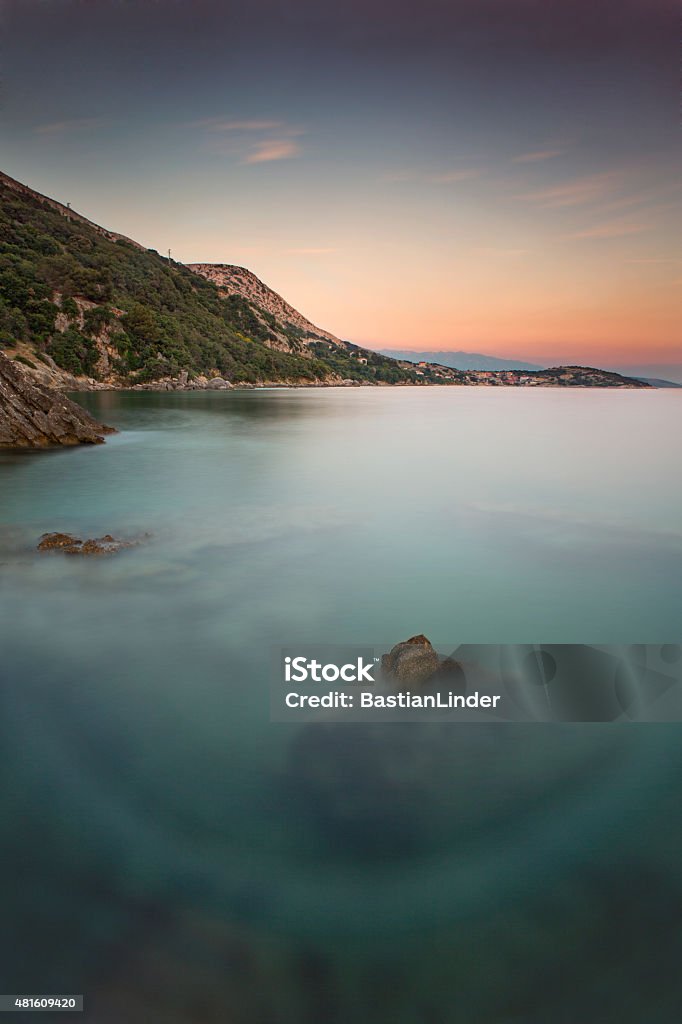 Coast during sunset in Krk, Croatia Coastline and sea with rocks during sunset in Krk, Croatia 2015 Stock Photo