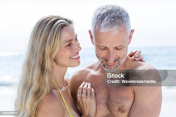 Happy Couple Standing By The Sea And Hugging Each Other Stock Photo - Download Image Now