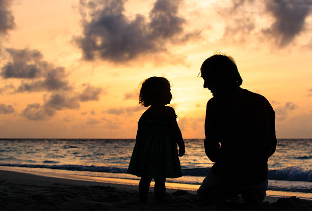 istock Father and little daughter silhouettes at sunset 481610014