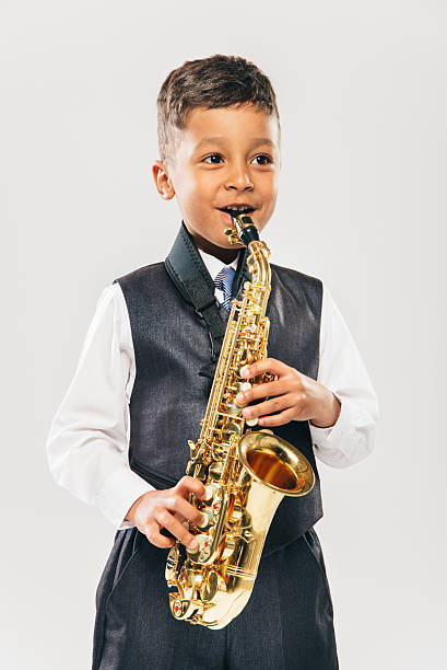 istock six years old boy plays saxophone at studio 481613694