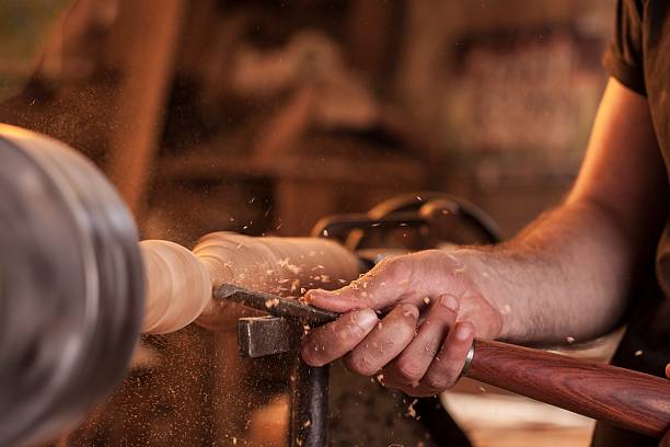 worker turning wood on a lathe stock photo