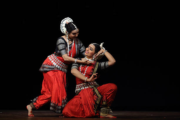 Odissi Bangalore, India - September 27, 2014: Renowned odissi dancer Mrs.Sharmilla Mukherjee performs odissi along with her disciple in an event entitled "Kinkini Nrityotsava", literally means the festival of dance. "Nrityothsava" is an annual event dedicated to promote Indian classical dances organised by the well-known Kinkini school of dance.  The event is arranged at JSS auditorium in south of Bangalore this year. Odissi is a classical dance style of Orissa state in the east coast of India. odisha stock pictures, royalty-free photos & images
