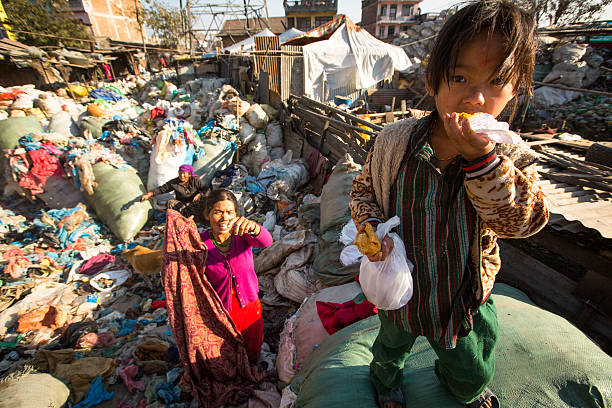 Kathmandu, Nepal - December 24, 2013: Unidentified child and his parents during lunch in break between working on dump. Only 35% of population Nepal have access to adequate sanitation.