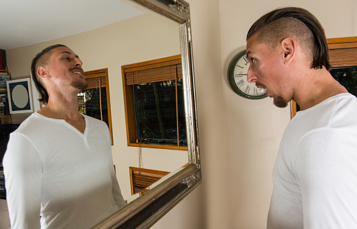 An image of a Caucasian guy in front of a mirror