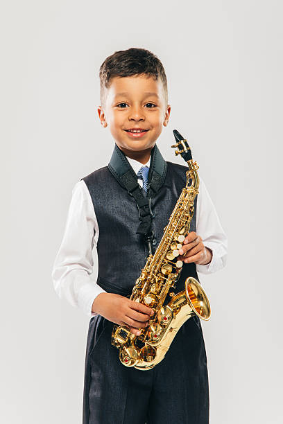 istock six years old boy plays saxophone at studio 481616344