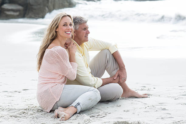 istock Happy couple sitting on the sand 481619906