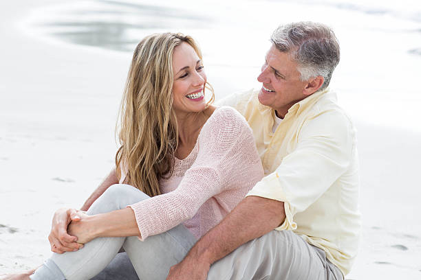 istock Happy couple sitting on the sand 481620062